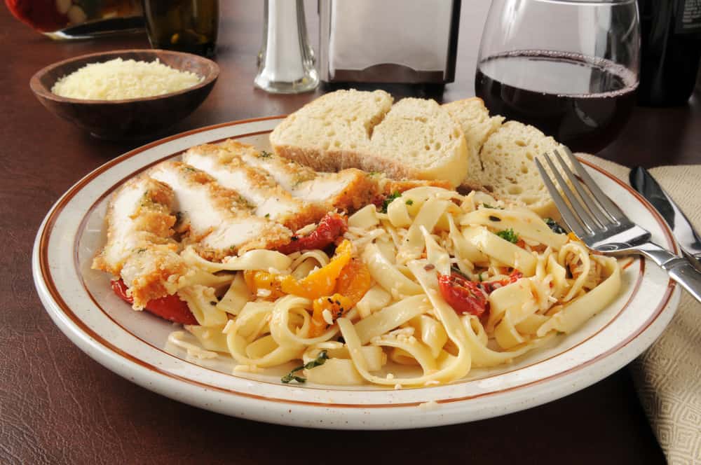 Chicken scaloppini with fettuccine Alfredo and roasted tomatoes with garlic bread