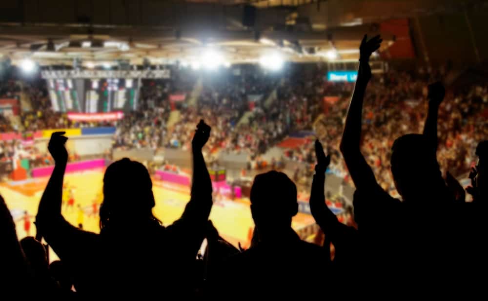 photo of silhouette of fans at a basketball game