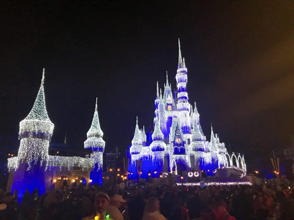The Magic Kingdom castle lit up with icicles at night.