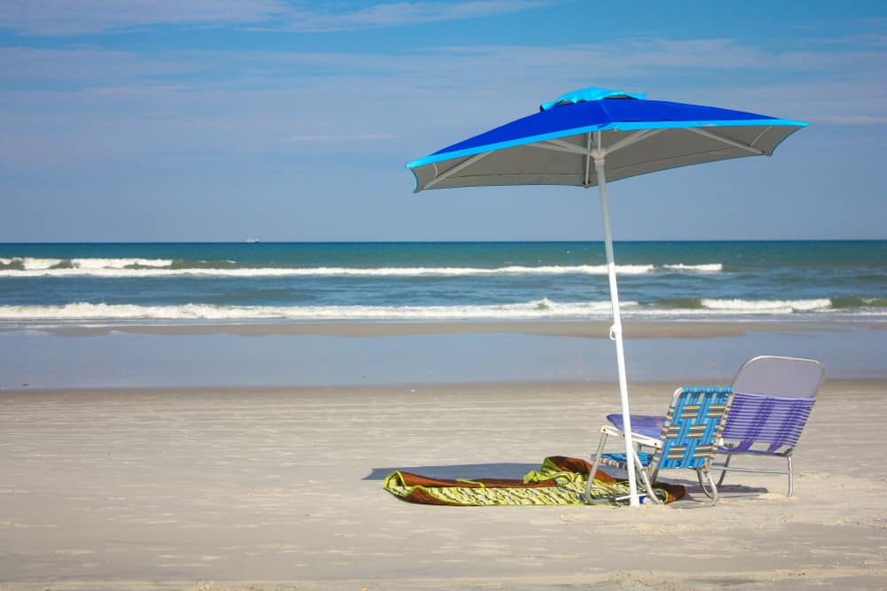 An umbrella and beach chairs on Neptune Beach one of the best beaches in Jacksonville.