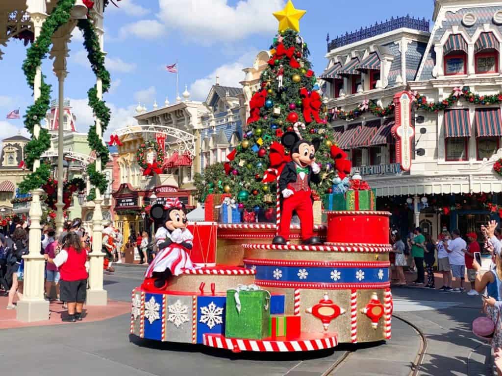 Christmas parade at the Magic Kingdom with Minnie and Mickey on a float with a tree and presents.