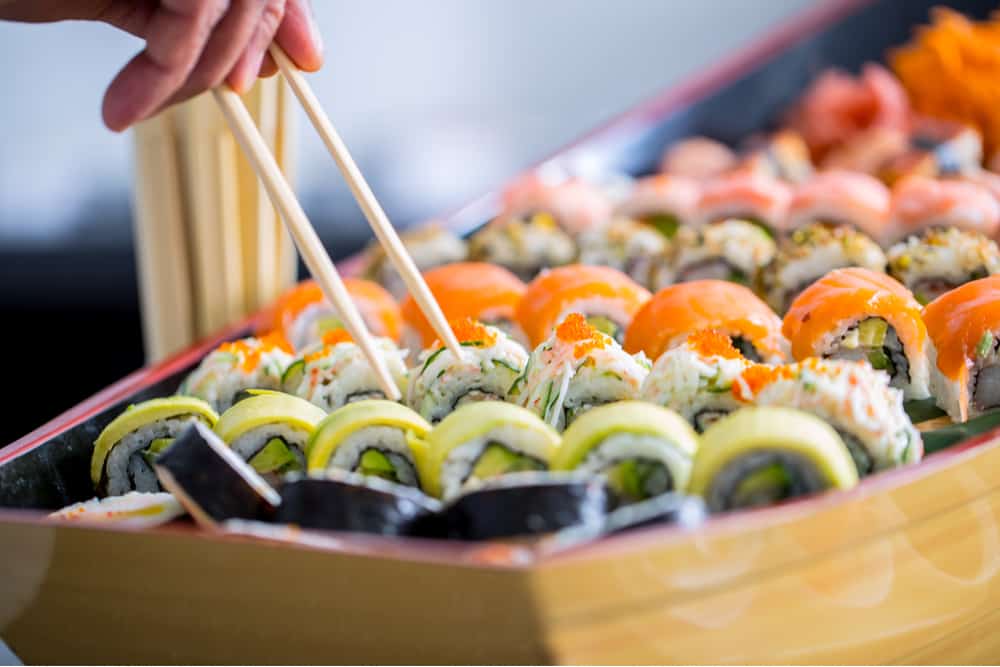 Chopsticks selecting a piece of sushi from the Sushi boat 