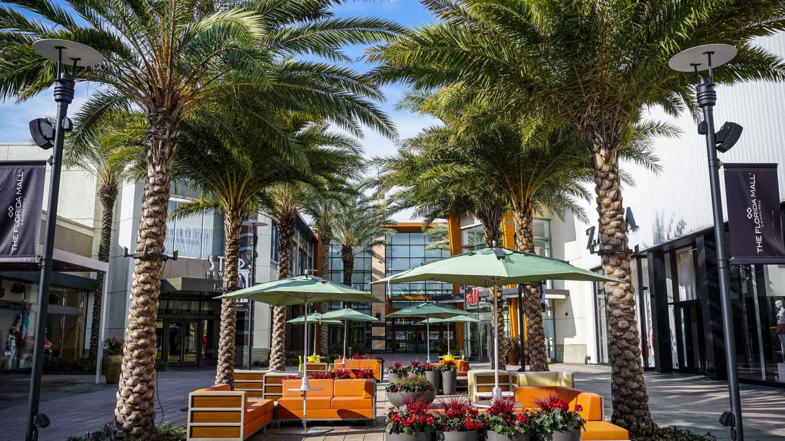 orange chairs and palm trees outside of one of the malls in orlando