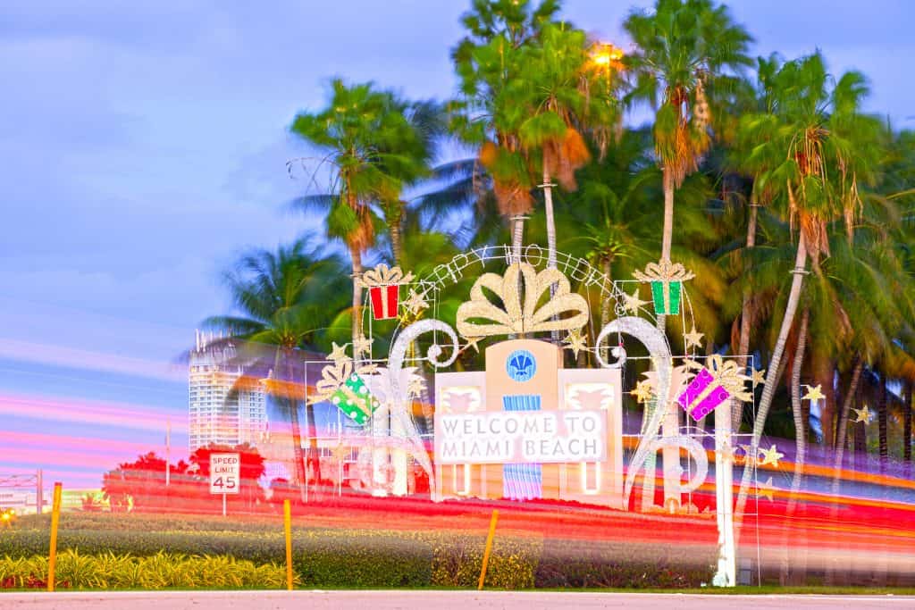 The "Welcome To Miami Beach" sign decorated for Christmas in south florida with blurry lights