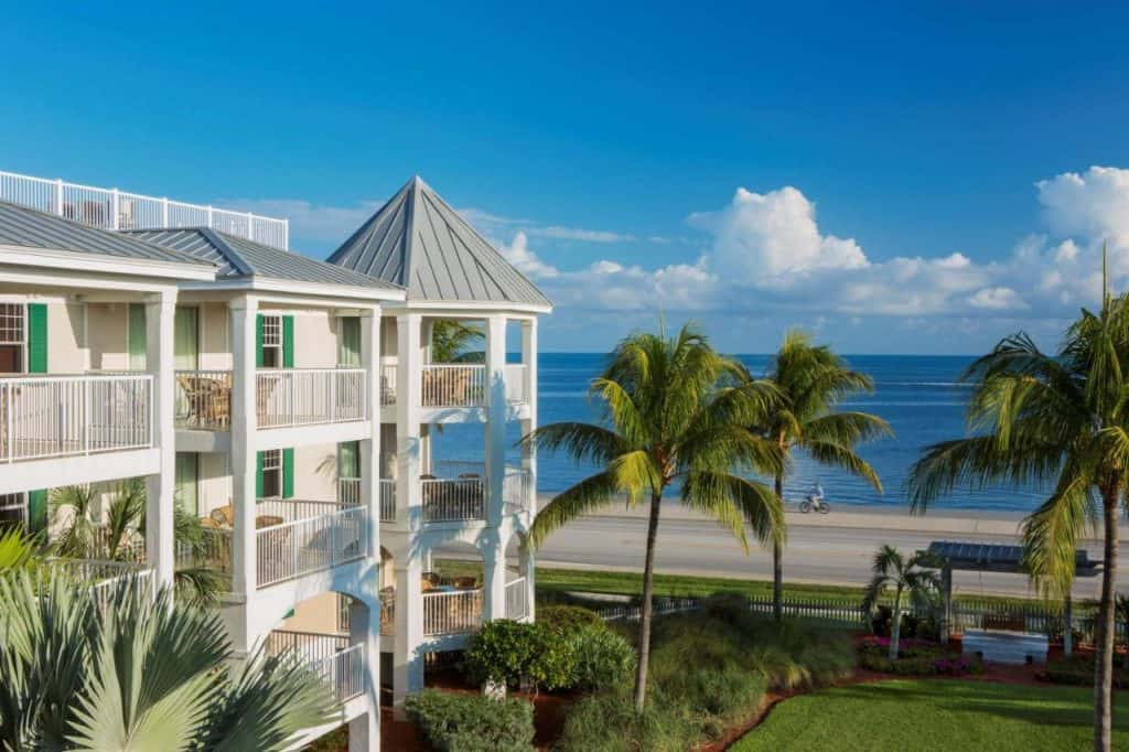 The Hyatt Residents Club in Key West features balconies that look over blue waters next to tall palm trees.