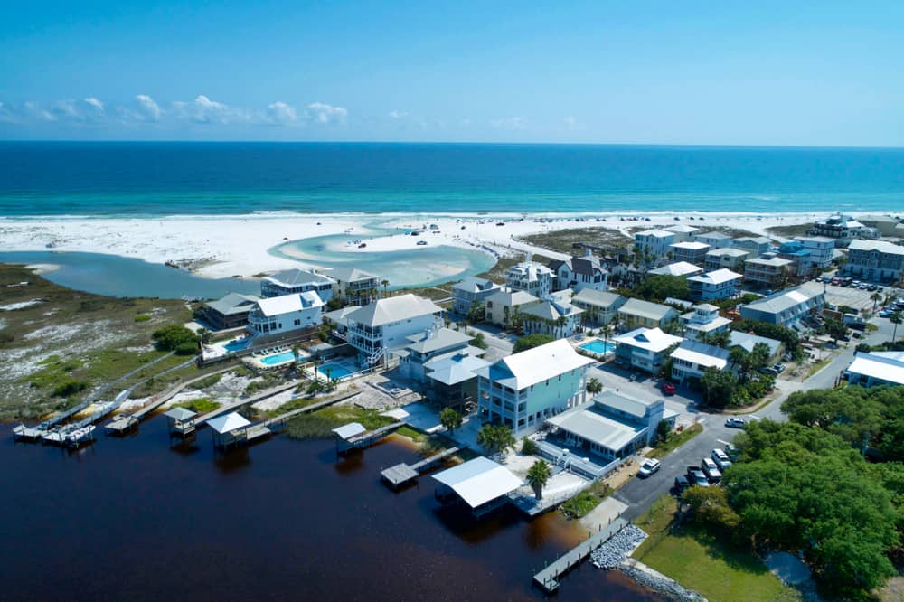 white sand and blue water with homes nearby at one of the beaches in Panama City