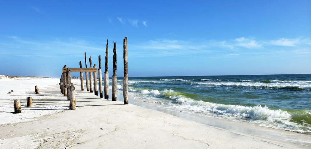 old broken wooden pier on shell island beach