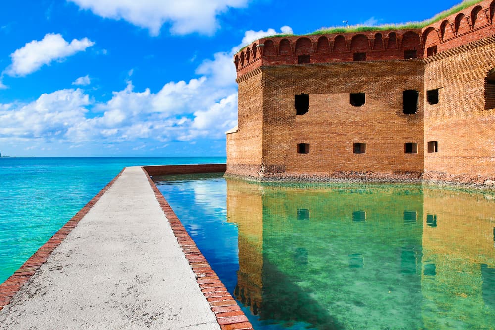 The walkway to Dry Tortuga's is made of brown stone and is a strong contrast to the blue waters that lead to the fort itself.