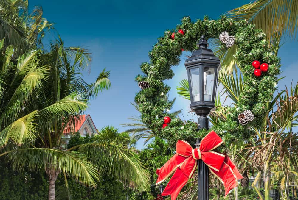 Key West in December features large decor, like this giant wreath with a large red bow, pinecones and more!