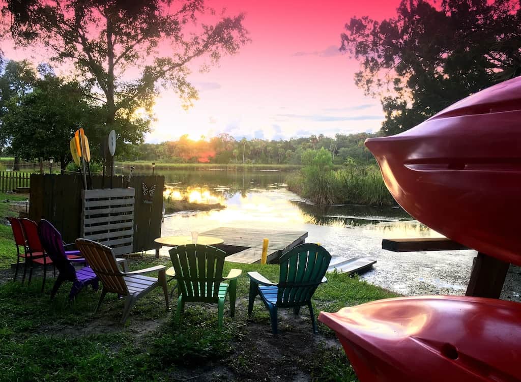 View of sunset over the dock and kayaks of the unique and charming waterfront cottage.