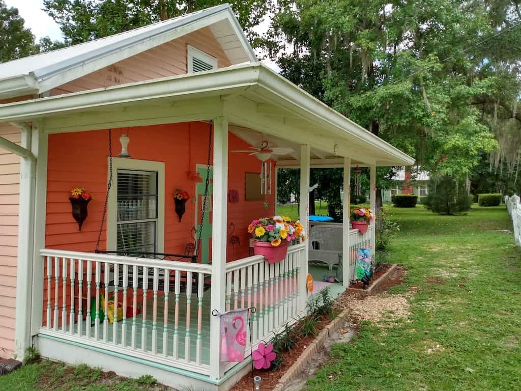 The flamingos nest is a pink shade cottage in white springs with a white picket fence and porch spring