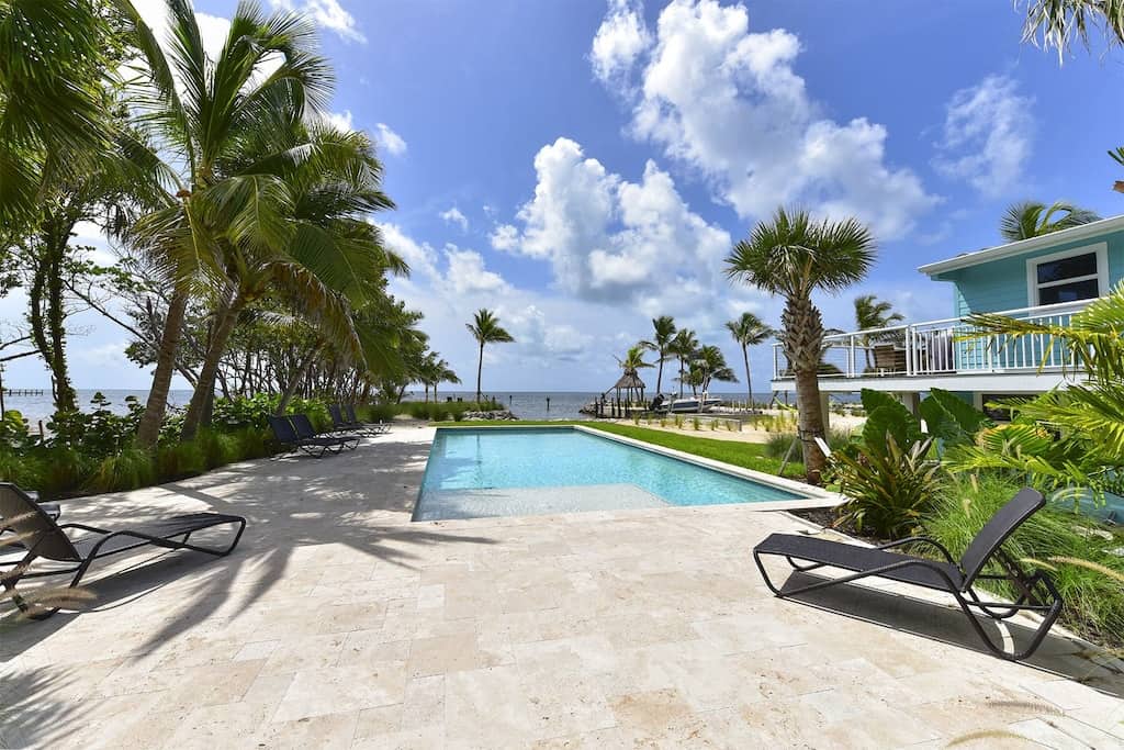 A private pool overlooking the ocean surrounded by palm trees