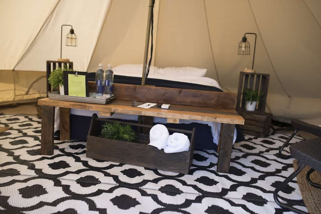 This luxury tent has a queen size bed with rug and seating area