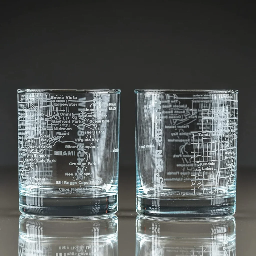 A picture of two whiskey glasses on a black and grey ombre background