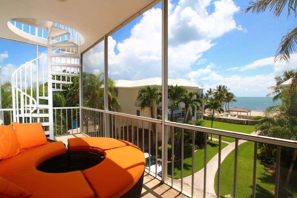 A modern orange sectional on the private balcony overlooking the beach, the palm trees, and the Atlantic Ocean. 