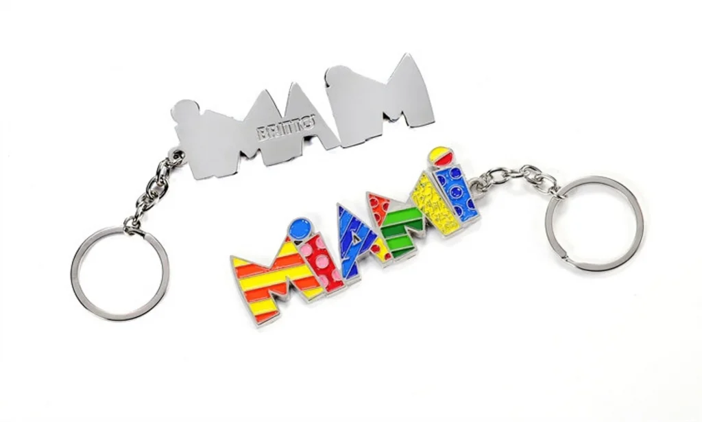 The front and back image of a colorful keychain that says "miami" in striped patterns on a white background. 