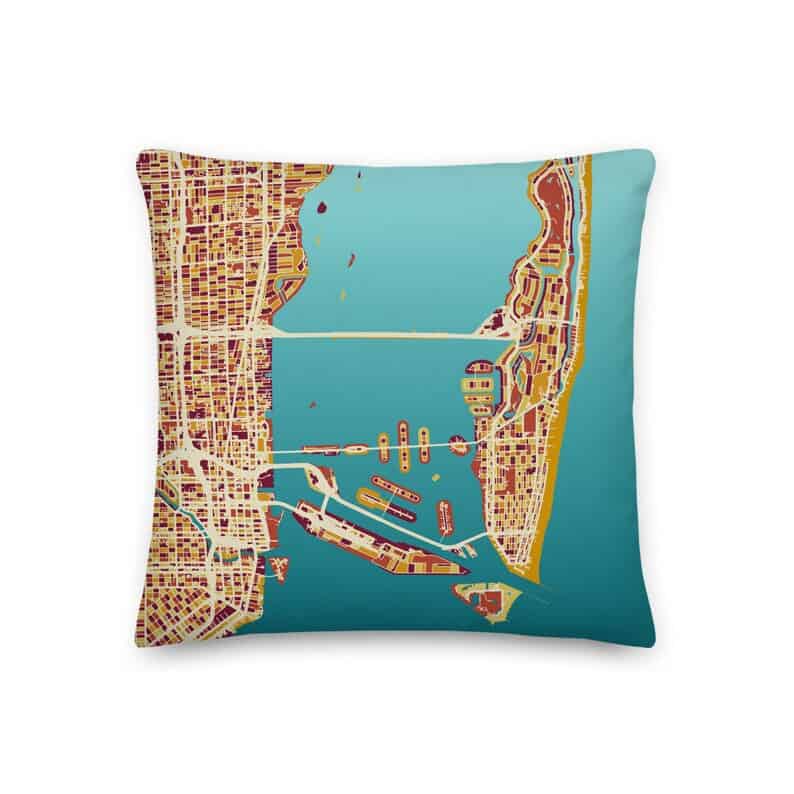 an image of a pillow with an artist's rendering of the city of Miami, using warm fall colors for the city blocks, and a light blue ombre for the water, on a white background
