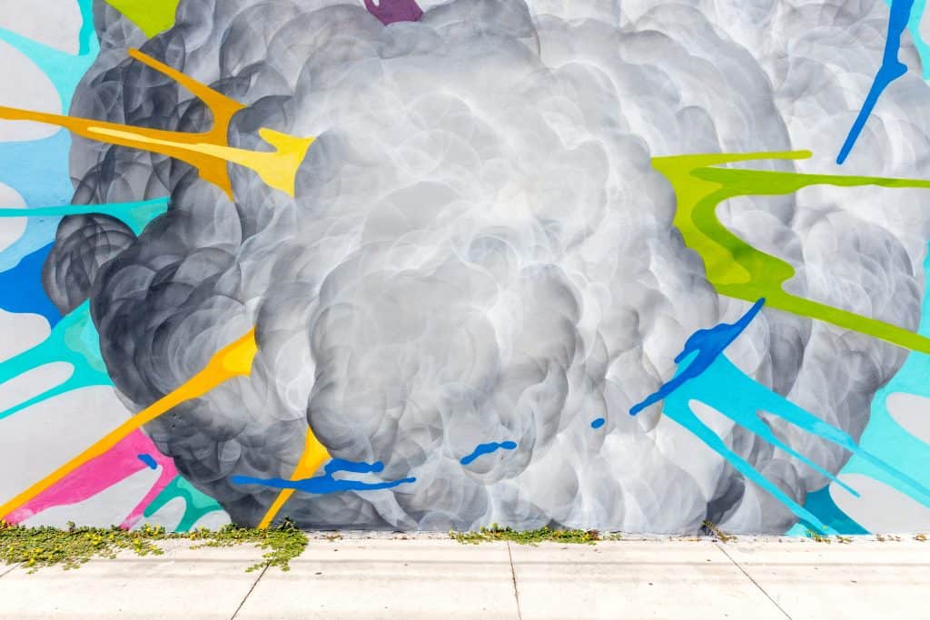 a picture of colorful graffiti depicting a cloud with paintstrokes of color coming out