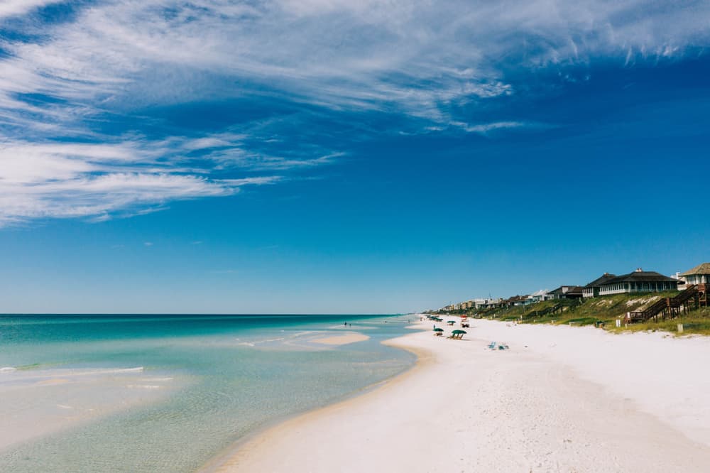 Aerial Shot of Rosemary Beach with bright blue water white sand and buildings some of the the clearest water in Florida