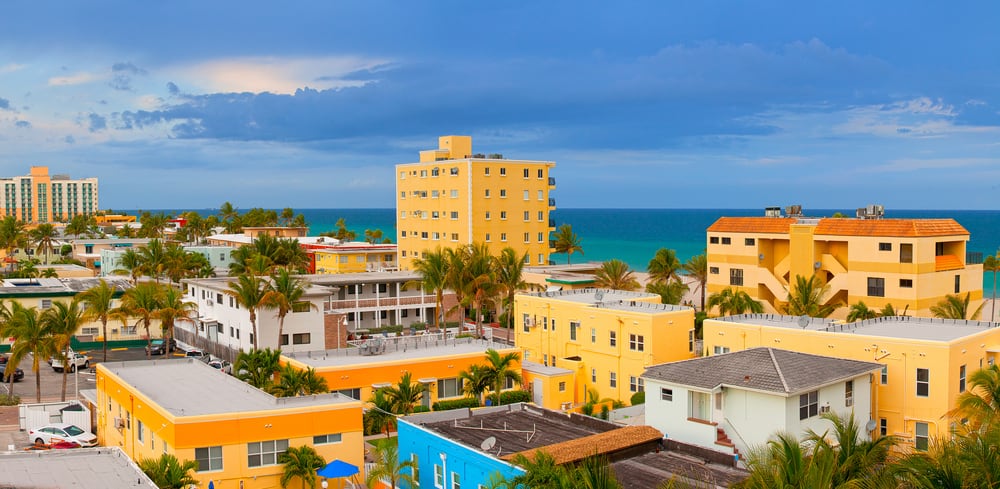 Colorful panorama of beach buildings and hotels on a sunny summer day in Hollywood, FL with ocean in the background.