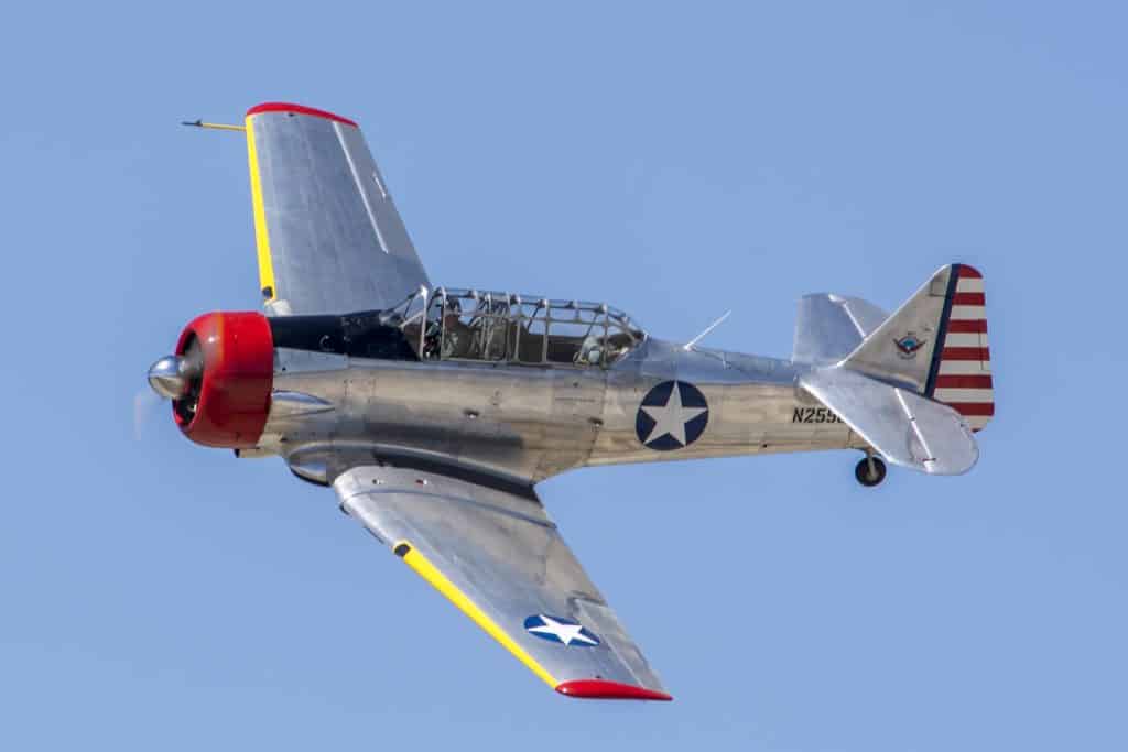 An old North American T-6 Texan flying in the air at War Bird Adventures.