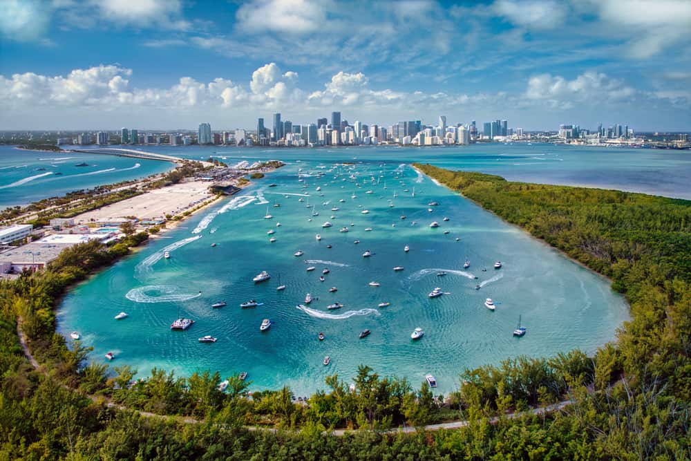 Key Biscayne is one of the best beach towns in Florida located off the coast of Miami with an Ariel view of downtown Miami and the turquoise water with boats in near Crandon park