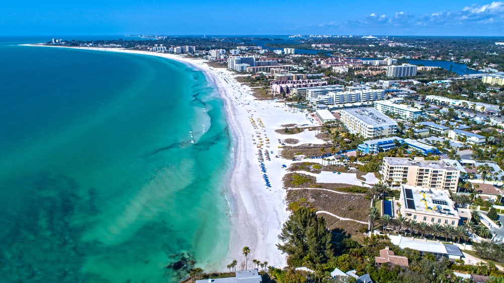 Ariel view of siesta key one fo the best beach towns in Florida with turquoise water and white powdery sand