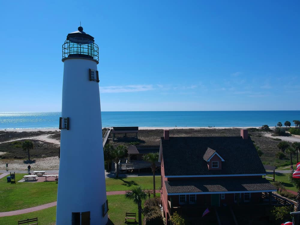 A white lighthouse over looking the beach on Saint George Island one of the best family friendly beaches in Florida