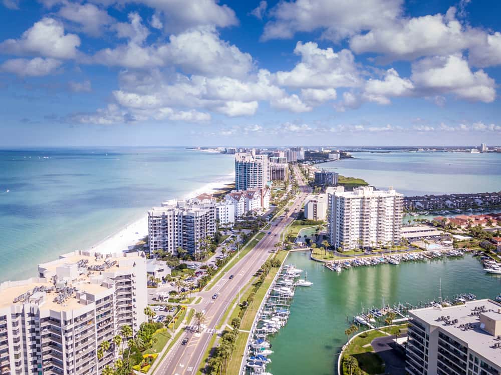 A view with the gulf ocean and Tampa Bay on the other side with high rise buildings and white sand