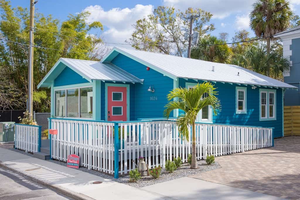 The exterior of the cute blue cottage next door and its salmon pink door. 