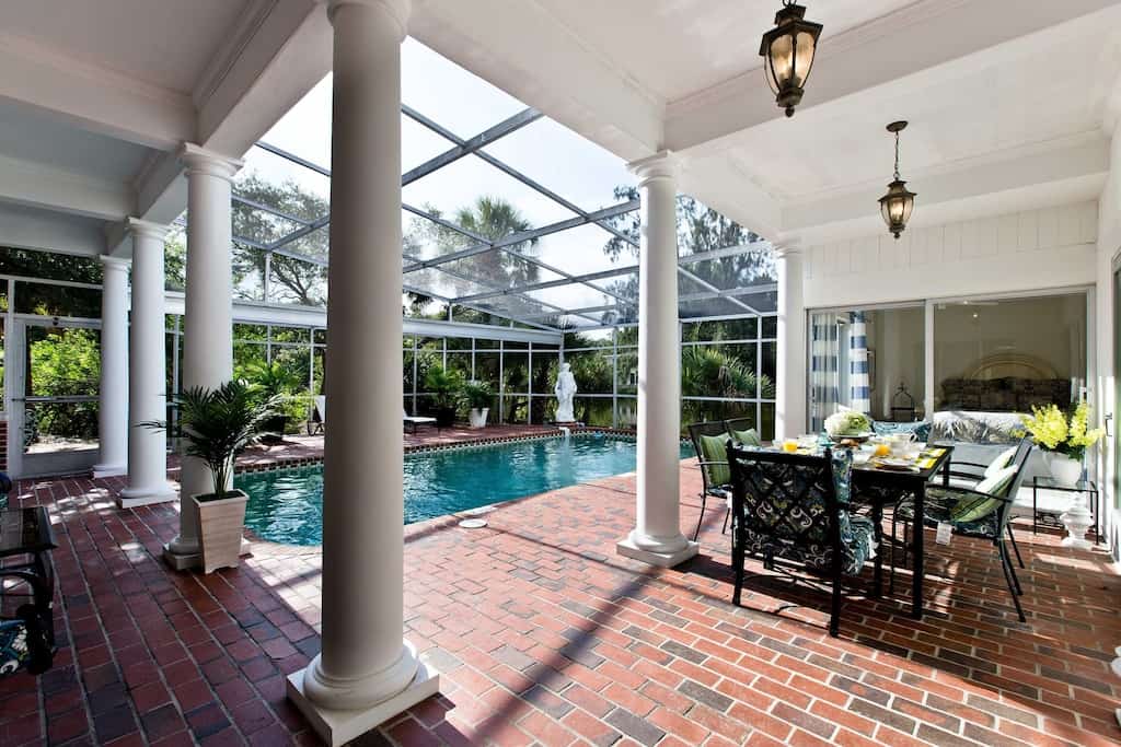 The screened in outdoor dining area and private pool of the lakefront oasis