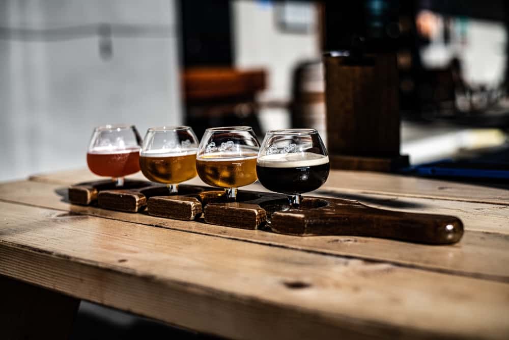 beer tasting flight on a wooden table with 4 different samples