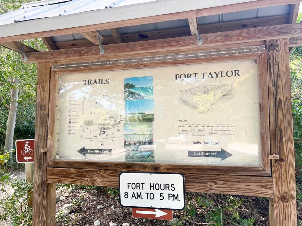 A wooden framed sign give visitors directions to the trails buildings at Fort Zachary Taylor State Park.