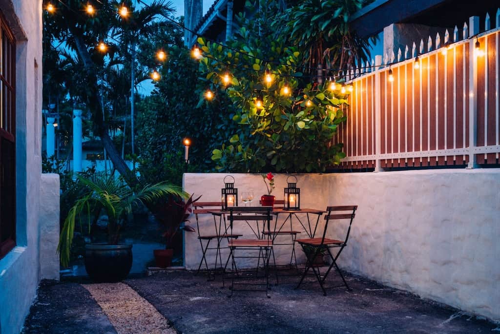 A romantic outdoor table with roses and candles set in the courtyard of the 1926 cottage. 