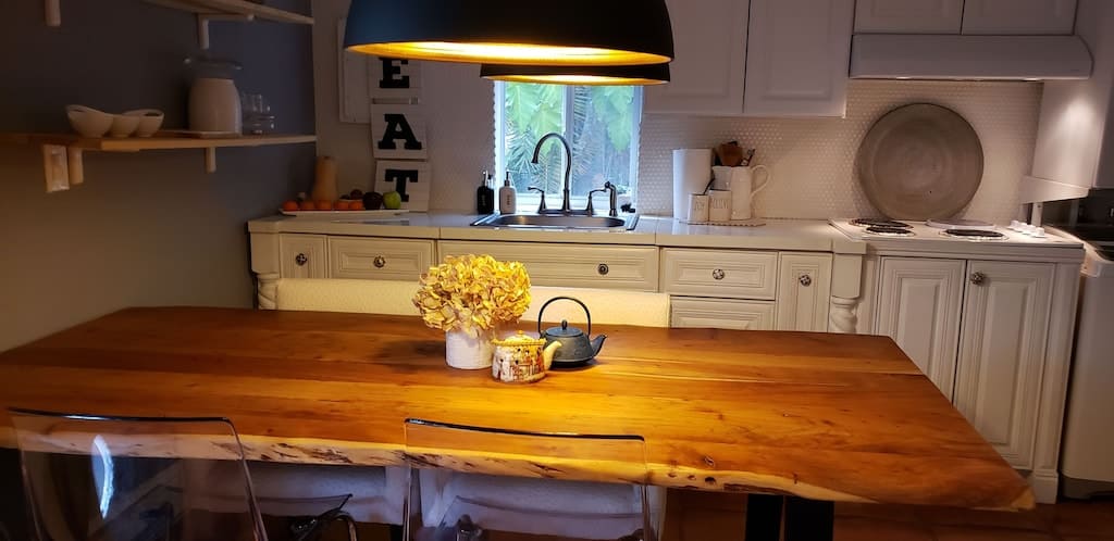 view of the live edge dining table and quaint cottage kitchen of the Miami cottagecore airbnb. 