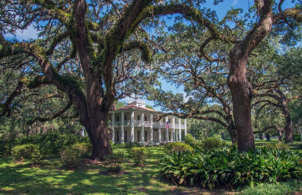 The Wesley historical plantation in Florida is at Eden Garden State Park a white historic home surrounded by oak trees 