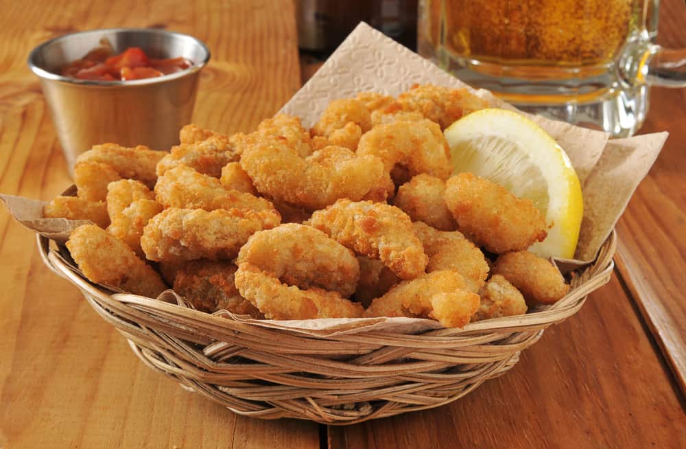 a popcorn shrimp basket with cold beer