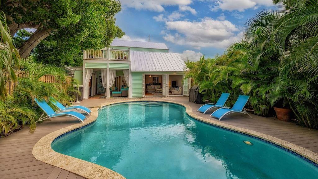 view of the huge private pool and mint green house of the Old Town Estate. 