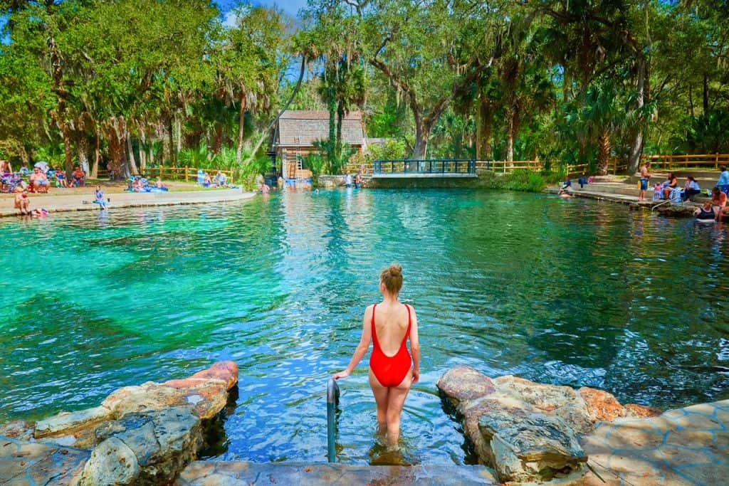 A woman in a red bathing suit overlooks the spring at Juniper Springs.