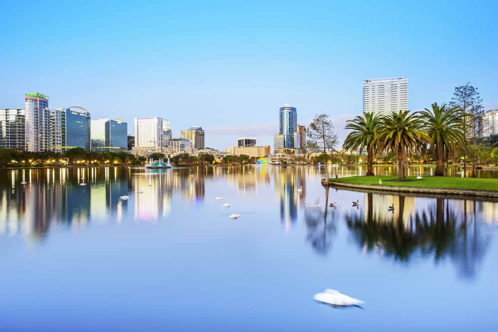 Lake Eola Park with building around the lake and palm trees 