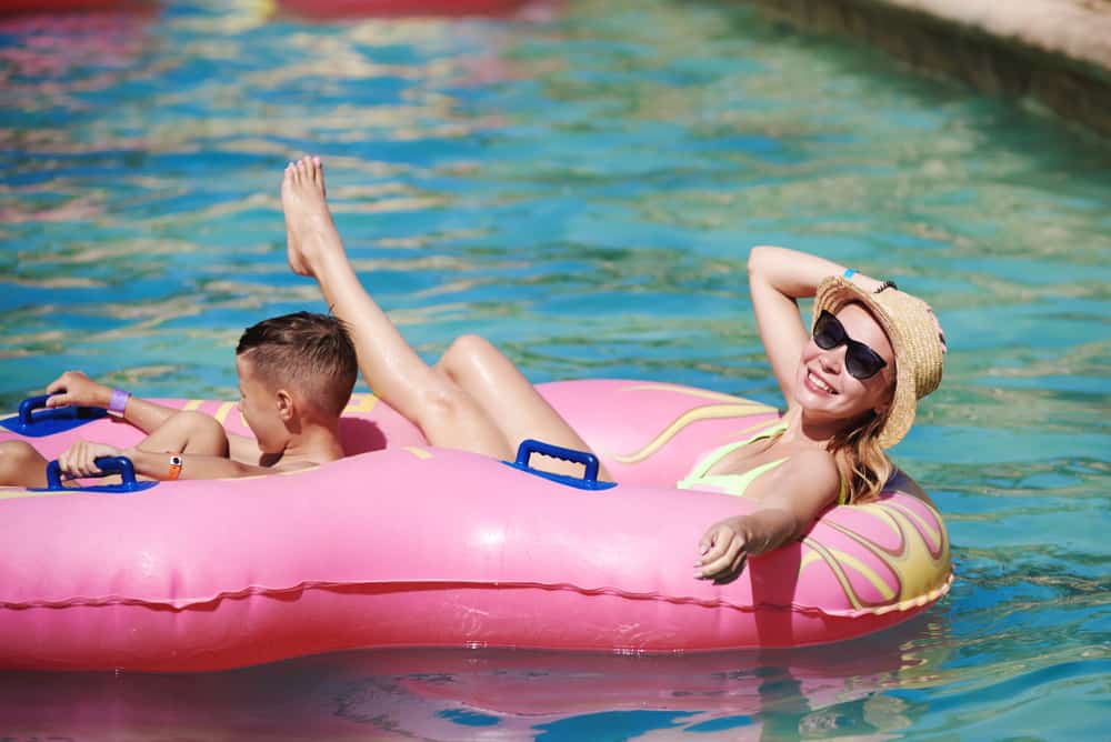 a woman an boy on a pink float at at a waterpark lazy river
