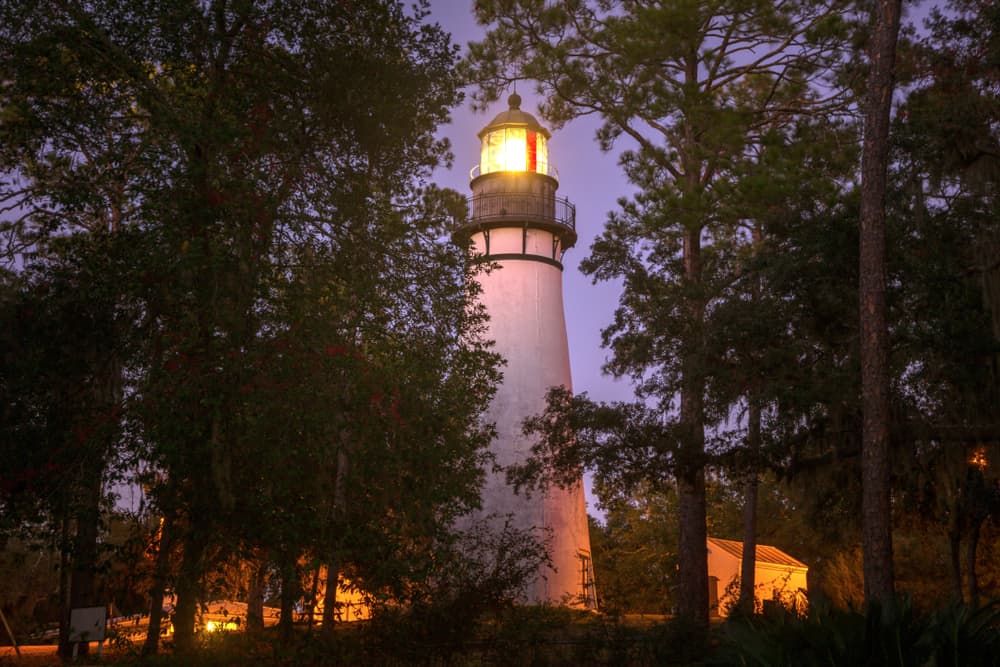 The historic Amelia Island lighthouse lit up at twilight. Its one of the best things to do in Amelia Island. 