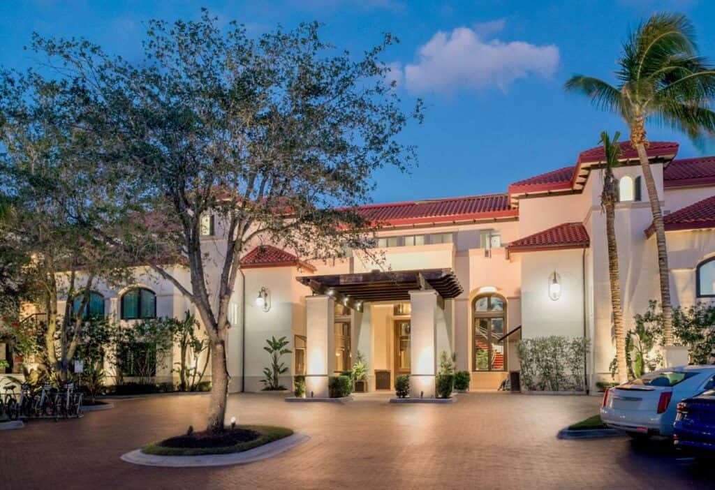 The valet and entrance of the bellasera resort, one of the best boutique hotels in Florida. The entryway is done in white stucco and bright orange roof tiles, giving it a regal mediterranean vibe