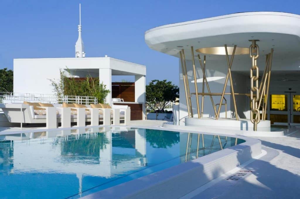 A daylight shot of the pool area in Dream Miami, the decor is done in all white and gold, which is a beautiful contrast against the blue of the pool water