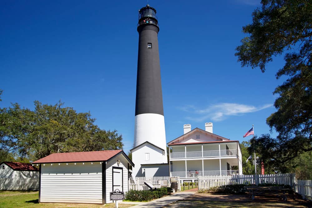 The black and white Pensacola Lighthouse stands tall above the old light keeper's house turned museum.