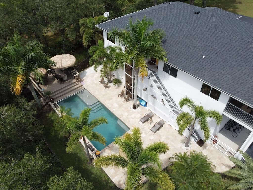 Aerial view of the epic backyard including pool and outdoor bar & grill of the private paradise. 