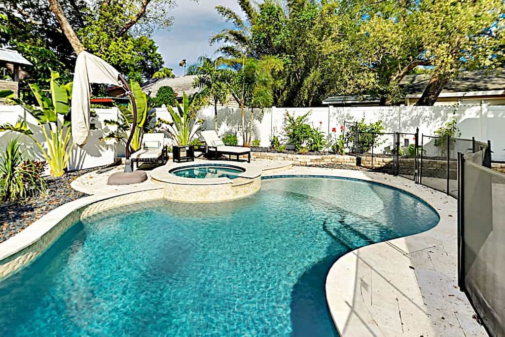 view of the pool and hot tub of this private luxury home in Tampa 