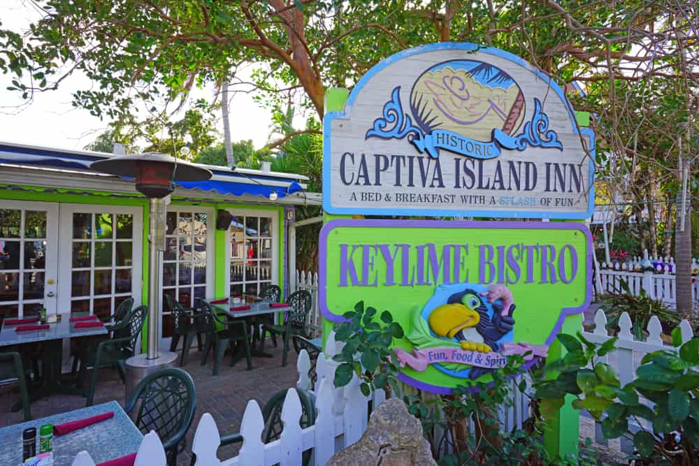 The outside of the Key Lime Bistro showing the sign and restaurant. Their are tables and chairs outside. It's one of the best restaurants in Captiva 