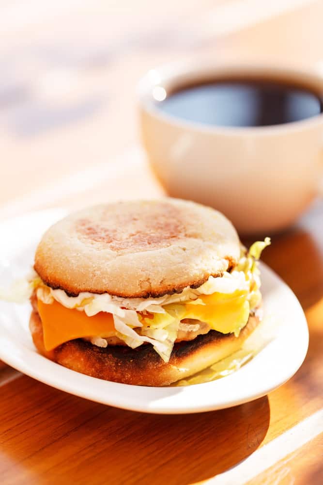 A breakfast bagel sandwich and a coffee on a table in an article about restaurants in Mont Dora 
