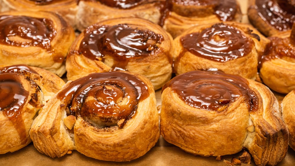 Crispy cinnamon rolls sit together on a baking pan, glazed with brown sugar icing: these can be found at Aunt Catfish, one of the best restaurants in Daytona Beach.